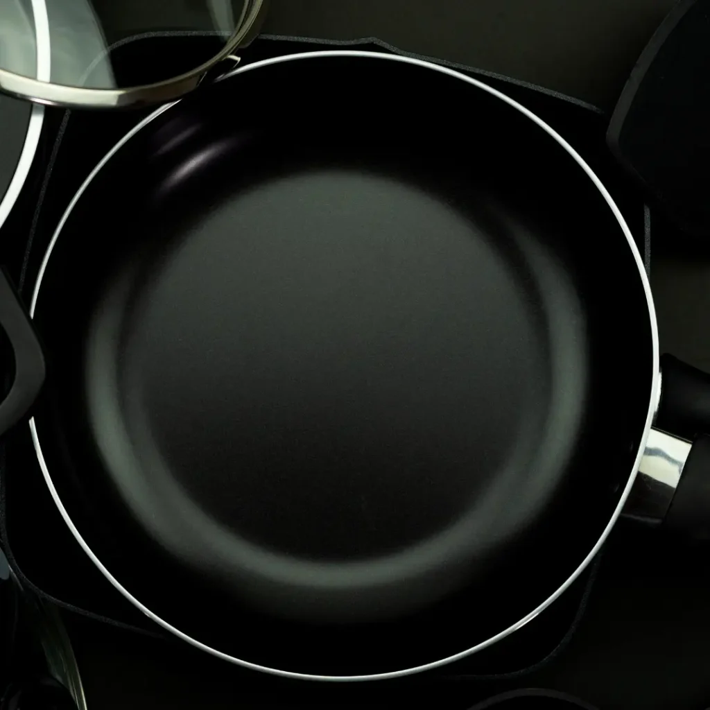 Potential Health Risks of Using Non-Stick Cookware Close-up of a black non-stick frying pan, highlighting potential concerns over toxic coatings.