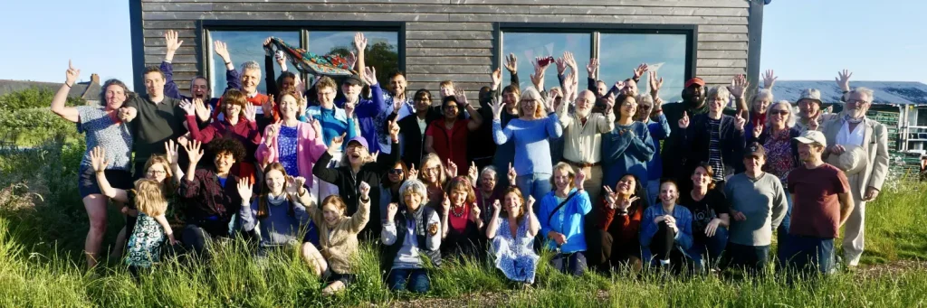 Large group of volunteers and supporters posing in front of a building at Sutton Community Farm.