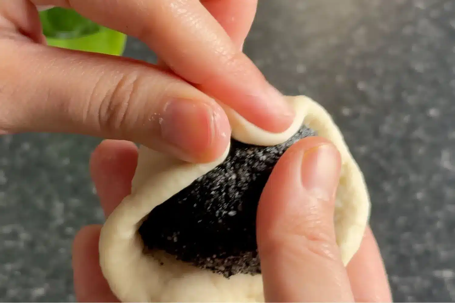 Black sesame filling being wrapped in dough